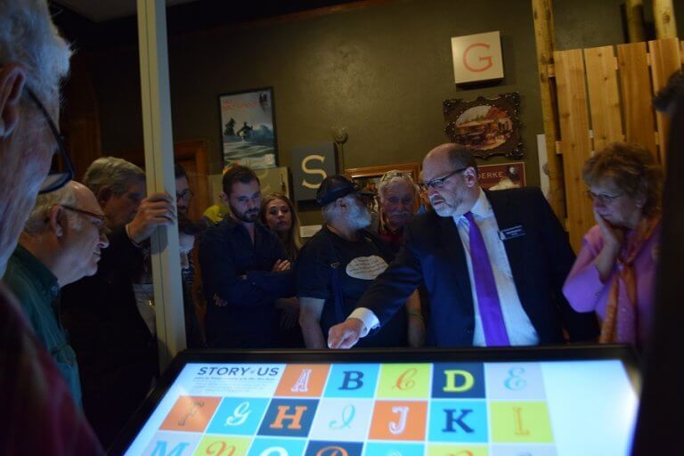 Director Matt Mayberry pointing to a touchscreen in the Story of Us exhibit.