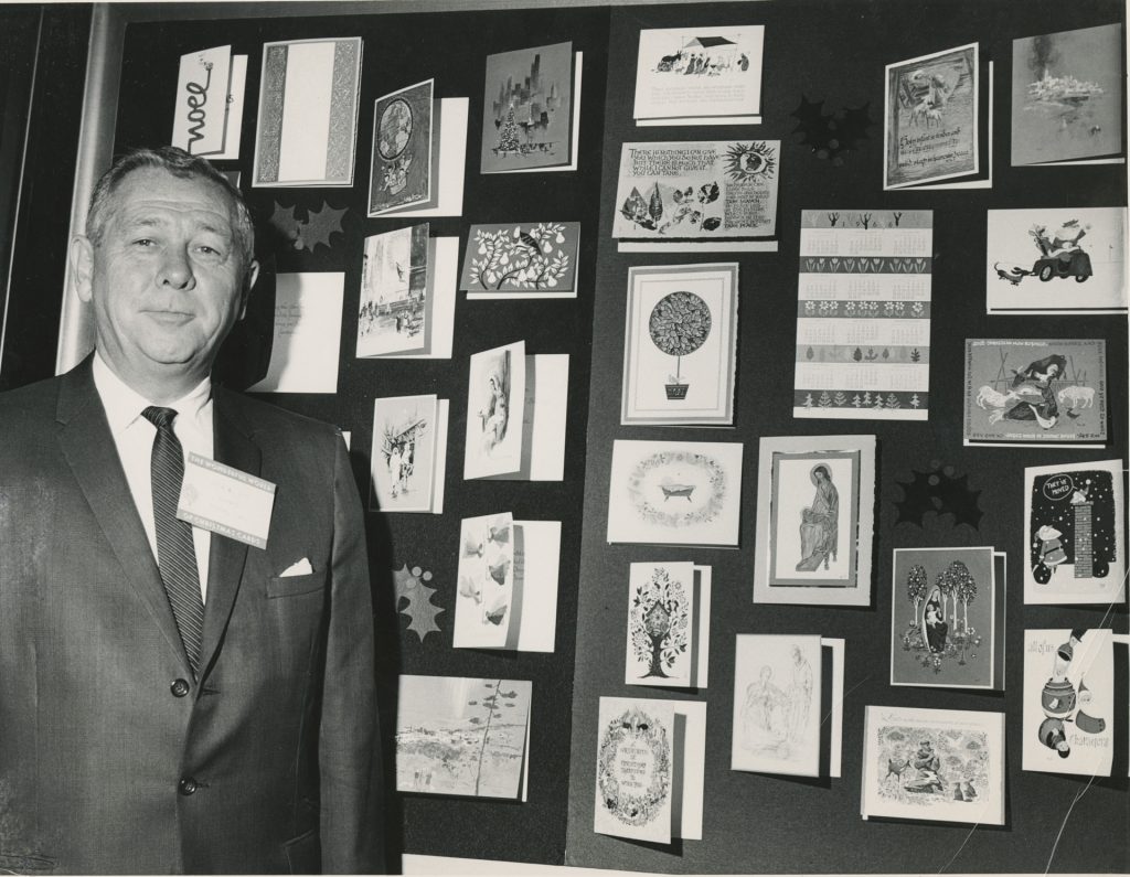 Gary Loo stands with a display of holiday cards, ca. 1955. Generously donated by Gary Loo, S2019.122.