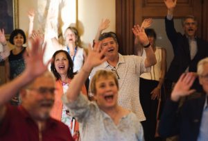 Group of excited people waving at camera.