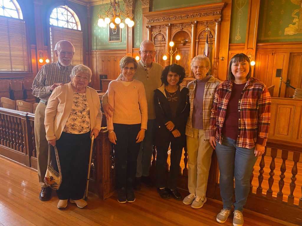 A group of five volunteers gather in the restored Division I Courtroom in the Colorado Springs Pioneers Museum.