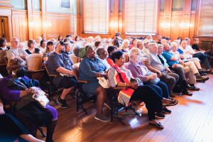 A group of people are seated in the restored Division One Courtroom