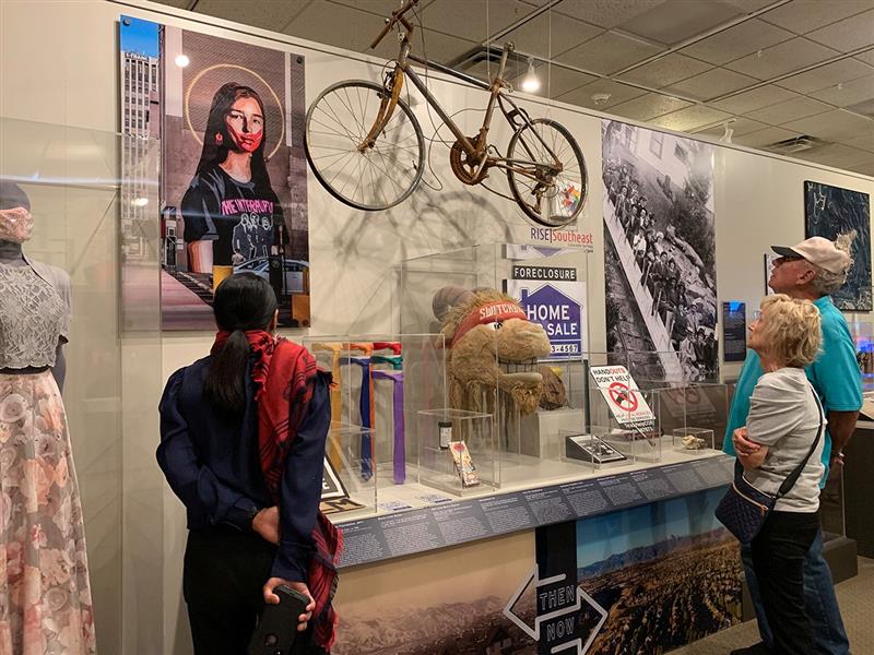 A group of people look at artifacts in an exhibit