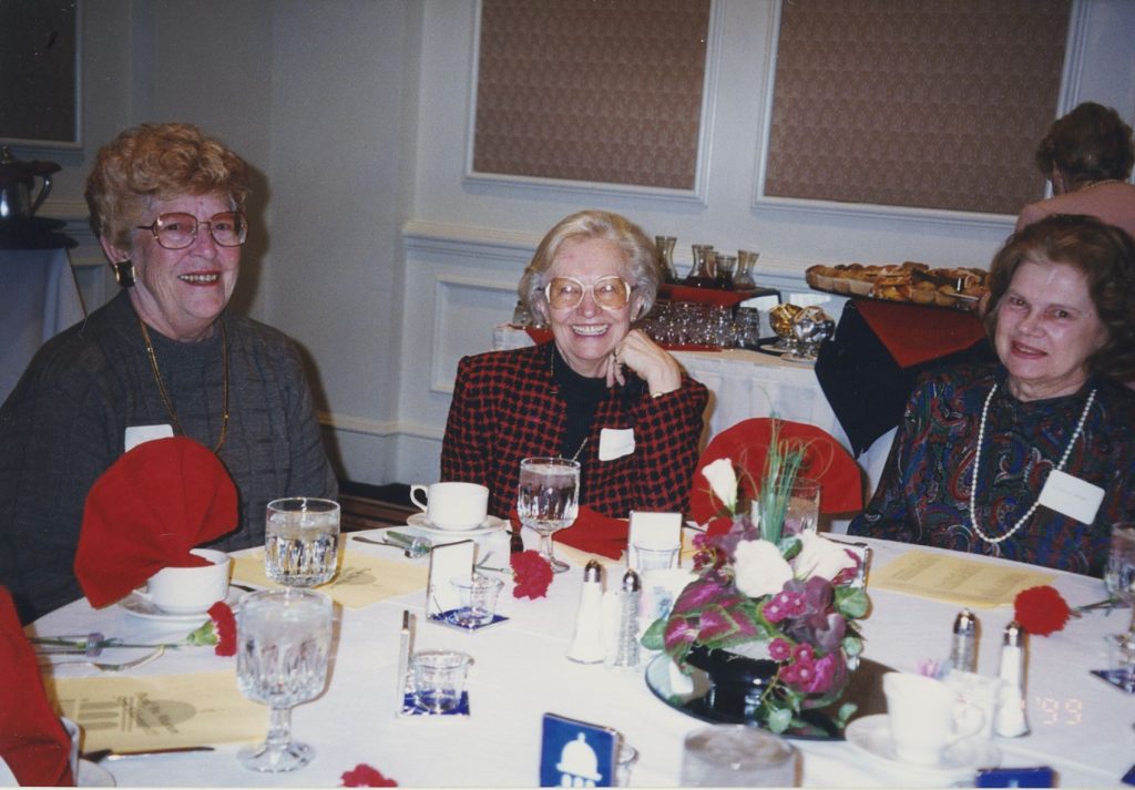 Three women sitting around a table eating brunch.
