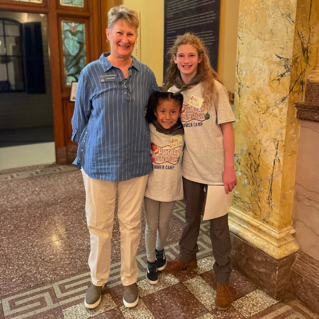 Nancy Bernard, CSPM Vice President and Volunteer, standing with two History Detectives outside "A Home of One's Own."