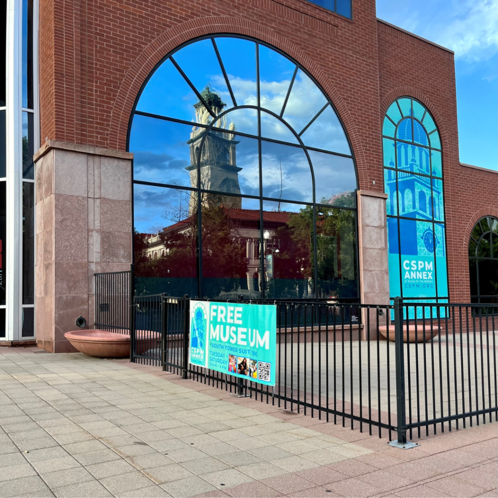 The outside of the CSPM Annex with the historic 1903 El Paso County courthouse reflected in the window.