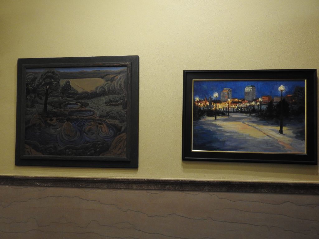 Left, painting of bathers in a natural spring; Right, painting of city at night, lights aglow.
