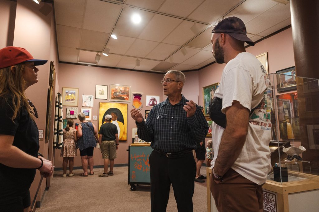 Gallery Attendant speaking with guests in the "50% of the Story" exhibit
