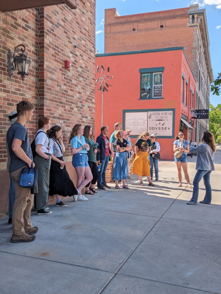 Museum Volunteer showing images to guests while outside on a walking tour.