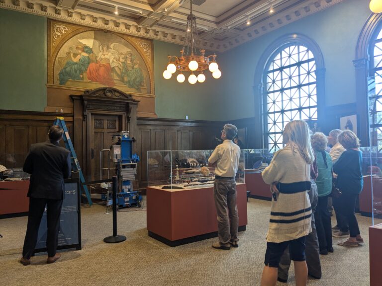A group looking at the Division III Courtroom Mural while it was being conserved.