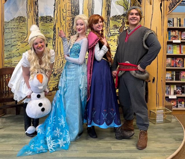 Four people dressed in winter fairytale clothing on a stage.